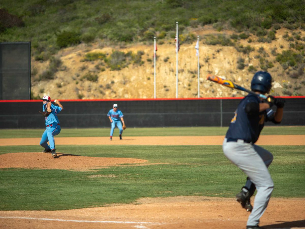 Evan Langer launches a pitch in the Ninth inning. He would eventually end the inning with a strikeout, securing a win for the Comets. (Others in photo: Noah Lazuka, Evan Jaquez) Photo credit: Josh Miranda