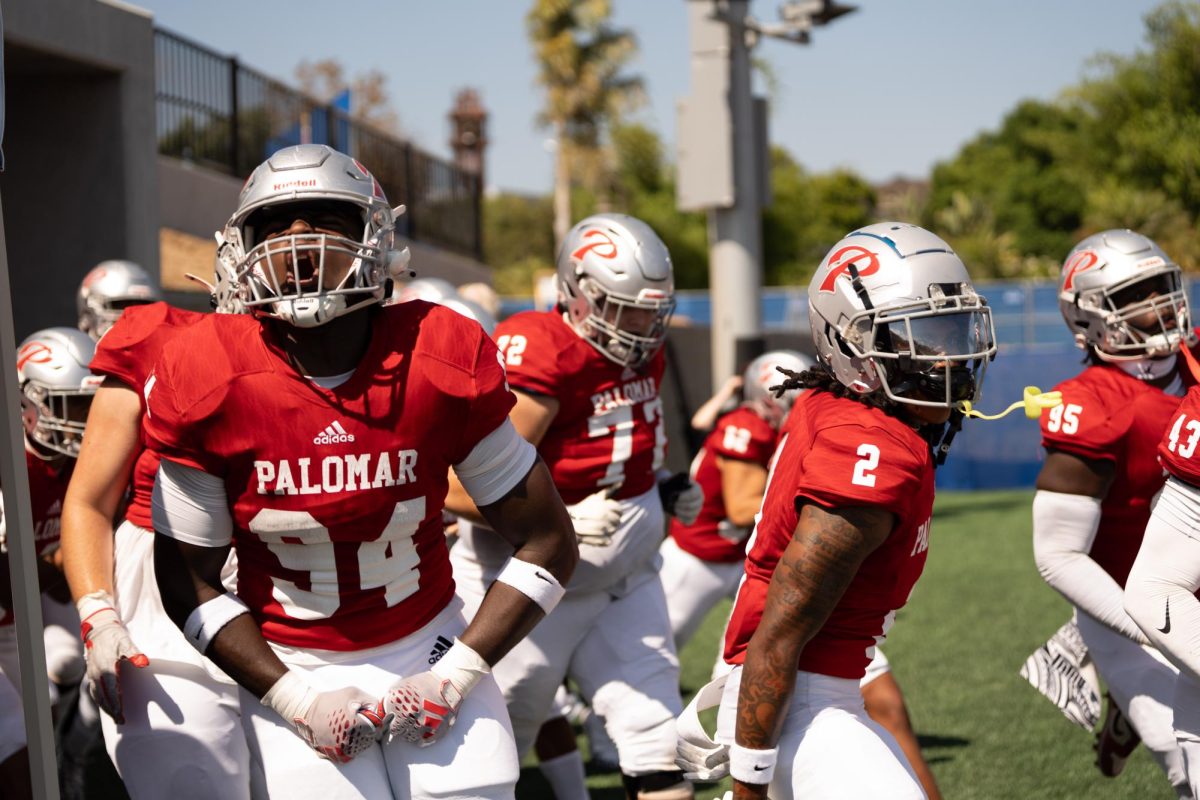 Palomar College #94 Kavion Hicks and #2 Davion Green run out of the tunnel before their game against College of the Canyons on September 21.