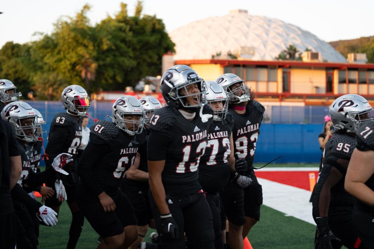 #13 Elijah Hudson runs out with the Palomar Football team before their game against Saddleback College.