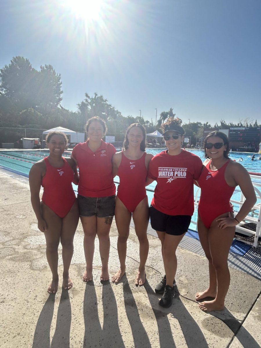 Coaches Mandy Simon and Kelly Rowan stand next to players Sophia Wicks, Madalyn McKellar, and Veronica Torres for a picture by the pool.