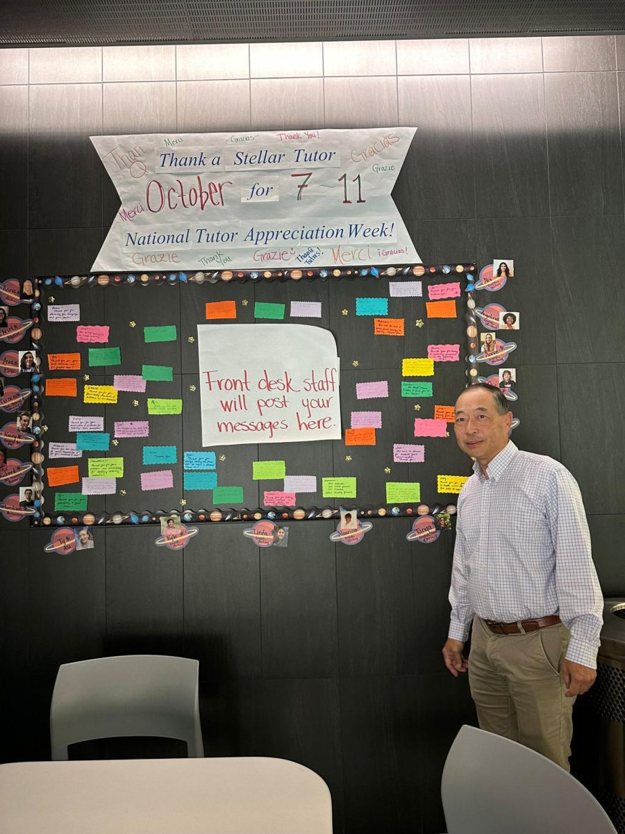 Alex Cuatok is standing in front of the tutor appreciation week wall. Photo credit: Olivia Reyes