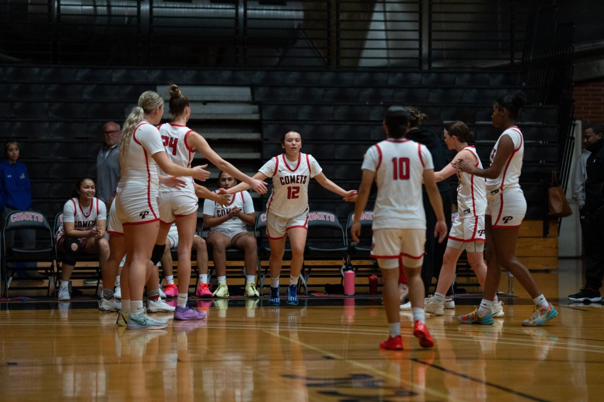 Brooke Quintana #12 runs out, giving high fives to teammates.