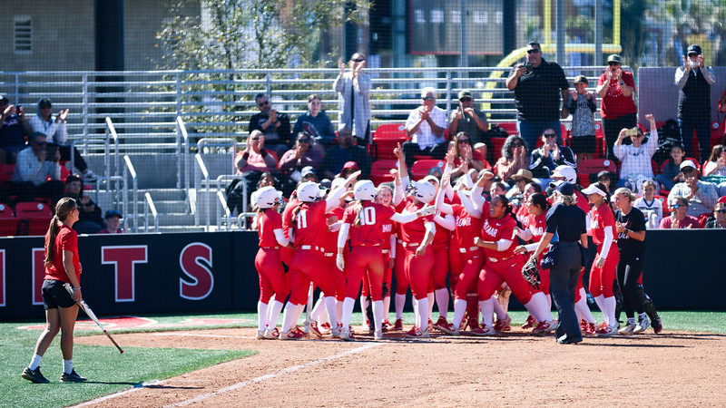 Breanna Lutz surrounded by her teammates after she hit a home run against Fullerton College on March 8. 