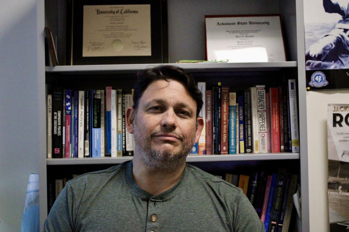 Peter Bowman, a political science professor at Palomar College, sits in his office in front of a bookcase in San Marcos, Calif. Bowman recently spoke with The Telescope about the uncertainty of democracy under the Trump administration.