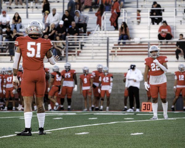 Palomar College's Hunter Stowe (#51) (left), wearing a red uniform and silver helmet, signaling to Giovanni Harte (#22) (right), wearing a red uniform and silver helmet, in the second quarter against San Diego Mesa College on Sept. 20, 2025 at Palomar College Stadium.