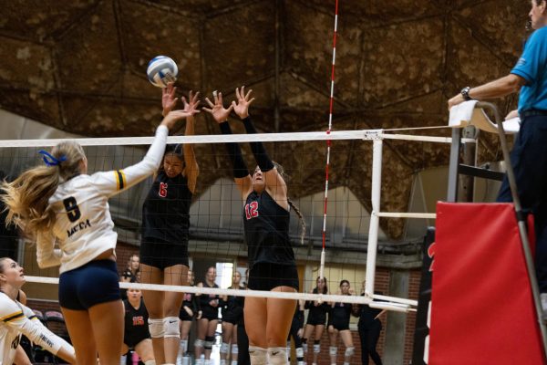 Teiora Tinoisamoa (#6) and Emma Bambe (#12) are jumping to block the ball that was spiked by San Diego Mesa's Bella Town (#8).