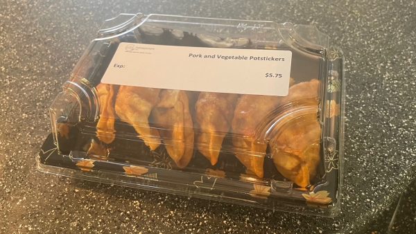 Five gyoza in plastic packaging with a white label that only lists what the item is and the price