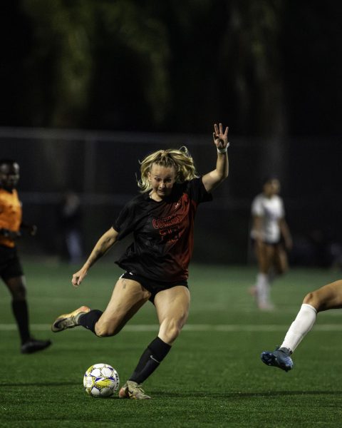 Palomar soccer player in black is about to kick the soccer ball with her right foot toward the opposing team's goal box during the second half of the game.