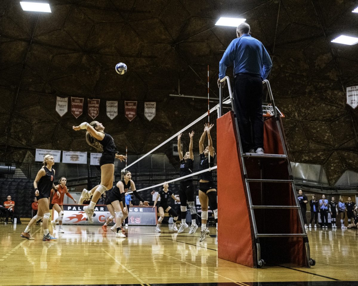 Palomar College outside hitter Emma Bambe (#12) spikes the ball against Miramar College defenders Niloofar Jorbozeh (#12) Abigayle Jerrell (#7) during the second set on Nov. 5 2025 at the Palomar College Dome.