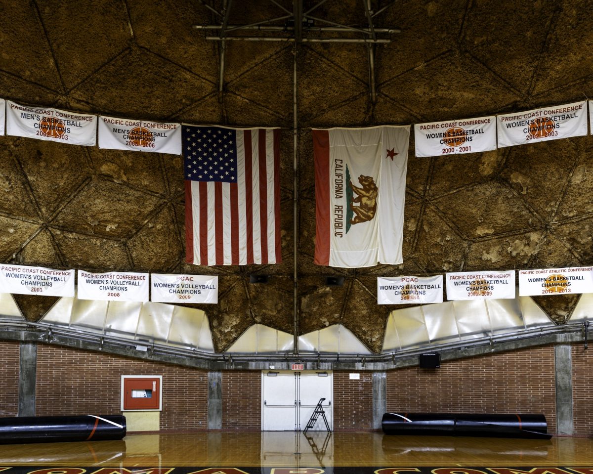 Las banderas de Estados Unidos y California cuelgan en el centro de la cancha, enmarcadas por los estandartes de los campeonatos de voleibol y baloncesto femenino a lo largo del envejecido interior de la Cúpula.