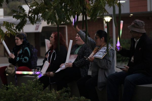 Students, faculty, and staff sit outside of the LRC building during the rally of Dec 16, 2025, at Palomar College.