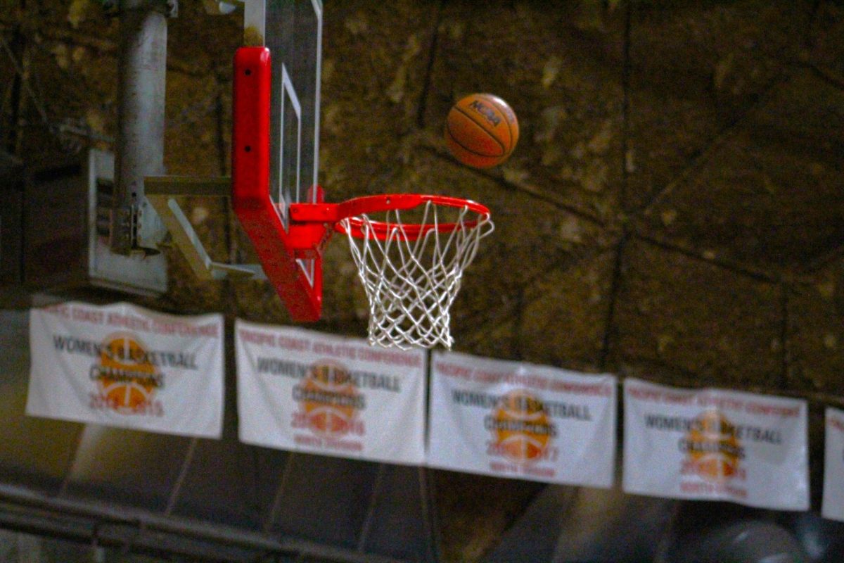 A basketball floats above a basketball rim on its path to a successful shot from an unpictured Palomar Comets women's basketball player.