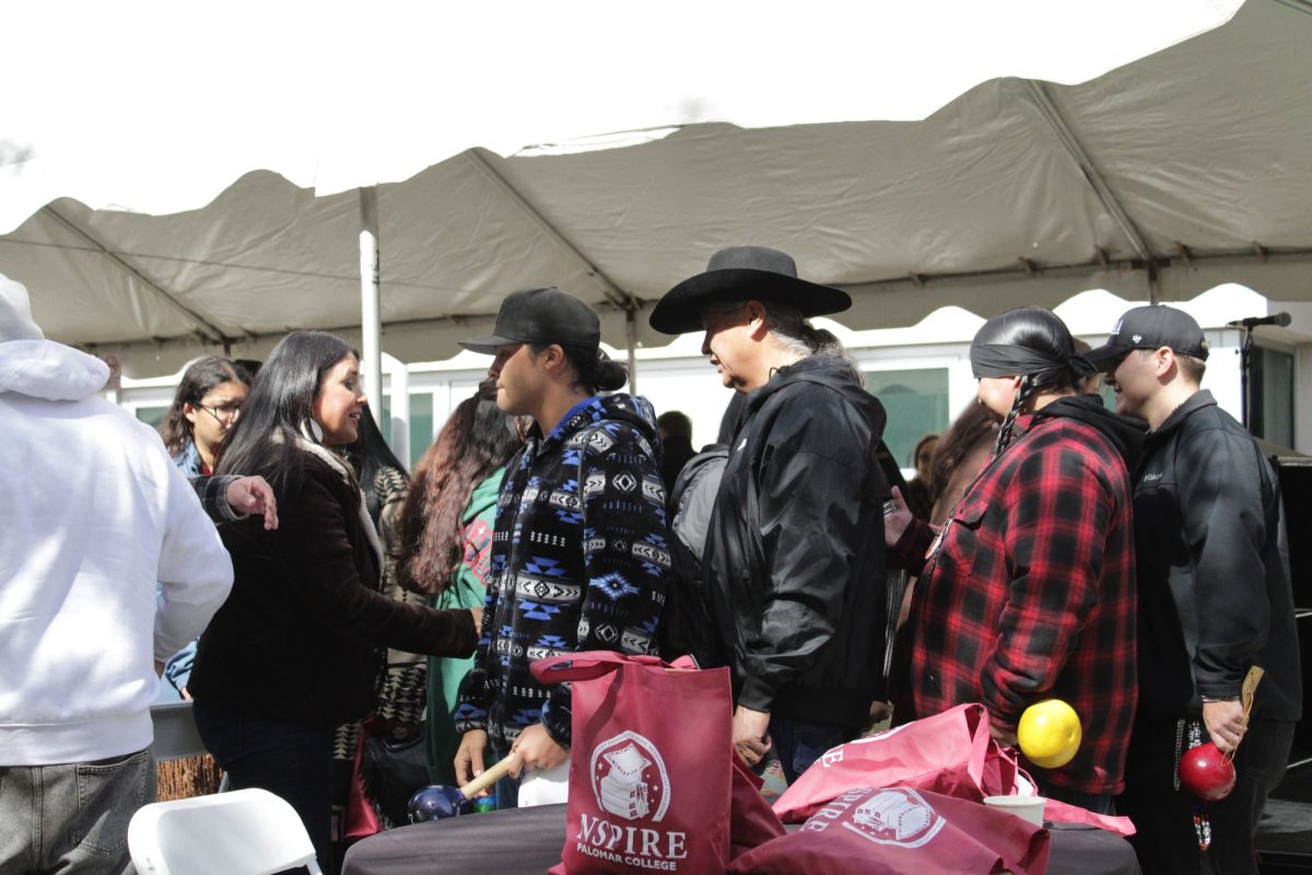 The Final Bird Singer Group shakes hands with community members after their performance