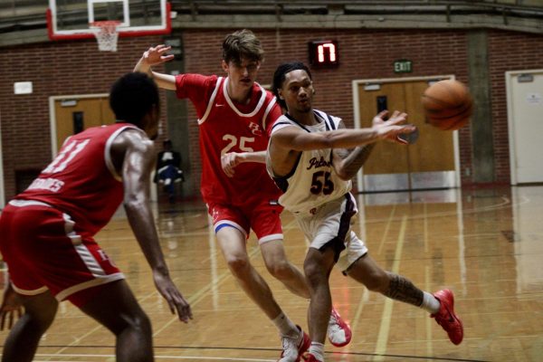 Jaidyn Norman (#55) is throwing the ball to his teammate (Not shown) while two Bakersfield players surround him.