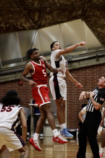 Justin White and a Bakersfield player jump in the air to claim the basketball at the start of overtime.