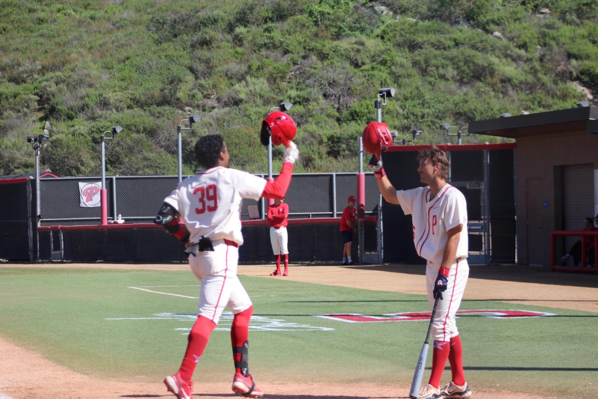 Pitcher Elijah Stephens (#39) taps helmets with Pitcher Michael Rodda (#36) after he rounds the bases