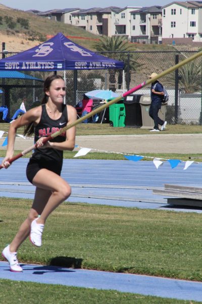 Kacey Tarlton sprints down the runway towards the crossbar during warmups for the Pole Vault Event.