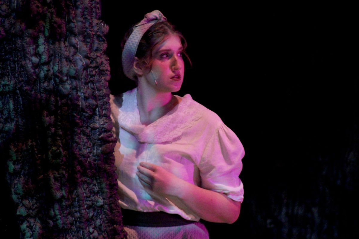 Autumn Lowe (Baker's Wife) hides behind the tree prop during a scene, including both princes.