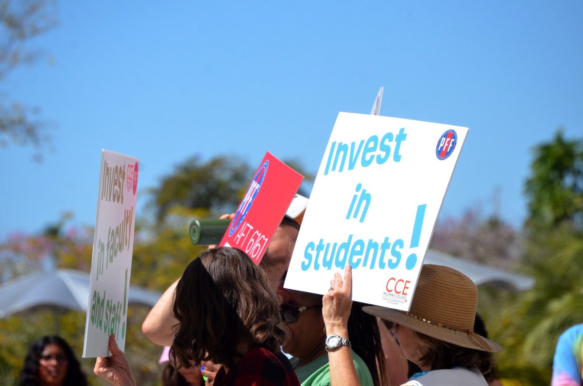 Rallyer holds up sign, "Invest in Students" while marching for the "March in March" rally on March 12, 2026 at Palomar College San Marcos. 