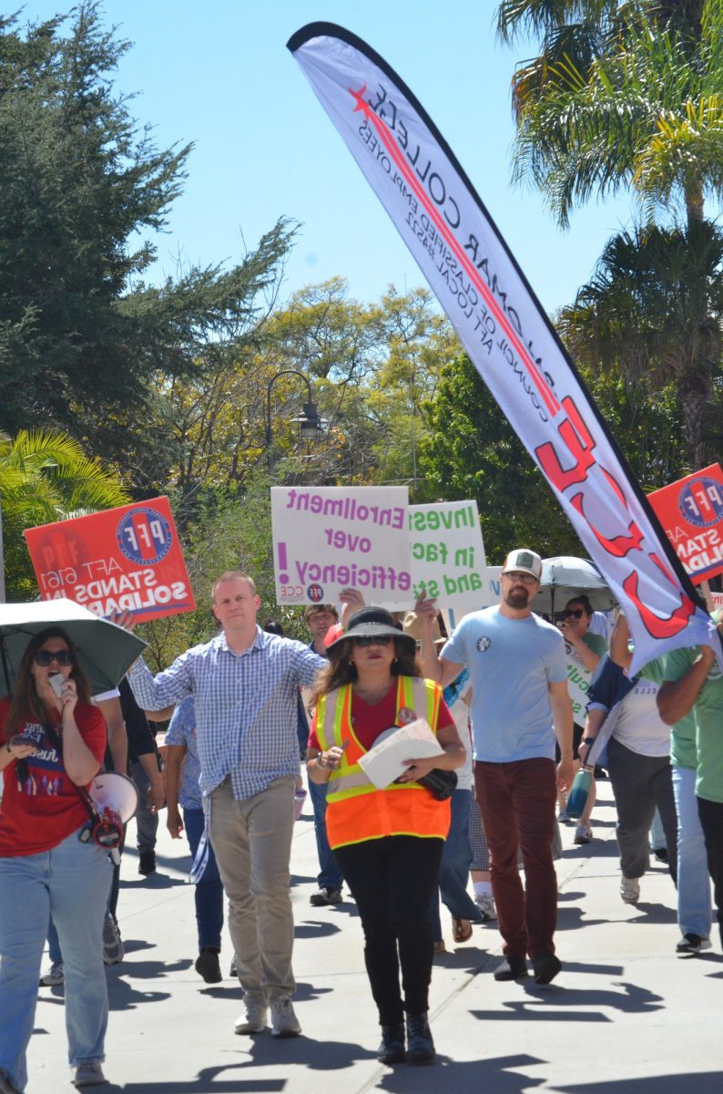 CCE President Anel Gonzalez (center) leads the march across campus flanked by PFF Co-Presidents William Dalrymple (left) and Lawrence Lawson (right) while Jena Kruhmin (far right) chants into the megaphone during a rally on March 12, 2026 at the Palomar College San Marcos campus. 