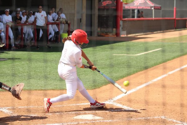 Palomar softball player Gisele Gonzalez wearing a white uniform number 1 swings her bat to connect with a pitch that resulted in a home run,