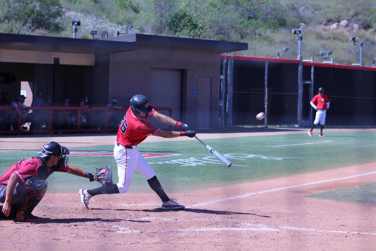 Palomar baseball player reaches out with his bat on a swing that connects with the baseball.