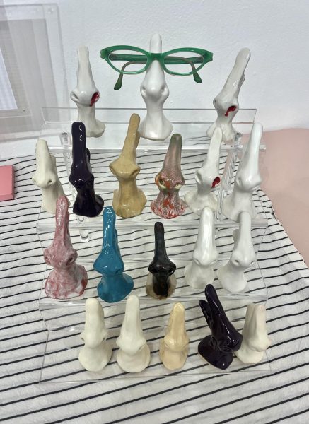 Stand with ceramic noses made to hold eyeglasses on Nicole Pyle's table.