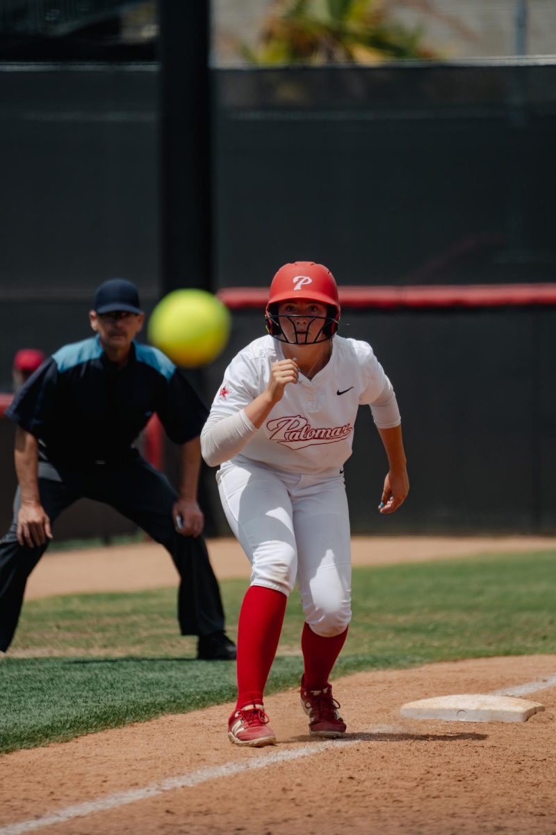 Comets Softball player #19 Grace McNally in position to run towards home base as the ball gets pitched to home on May 2nd against Ventura.