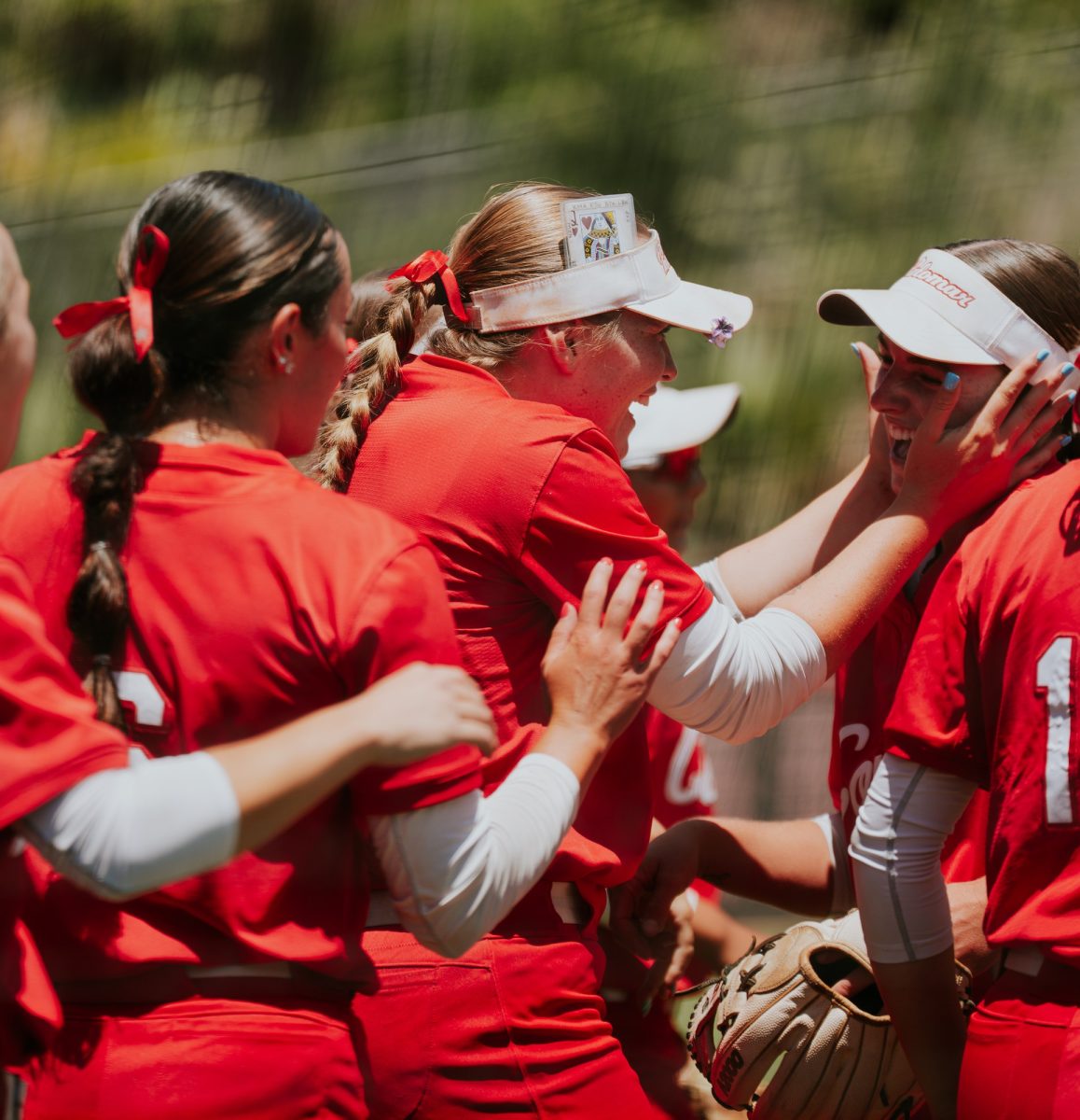 The women's softball team gather around pitcher Kiara Flaviani during game two against Antelope Valley on May 9.