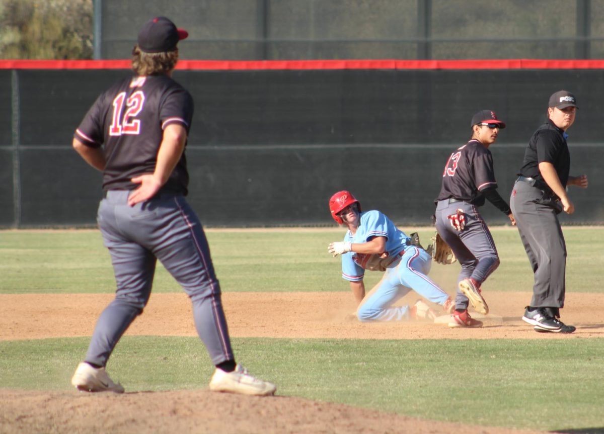 Palomar baseball player in a light blue uniform slides safely into second and looks up to see where the throw went.