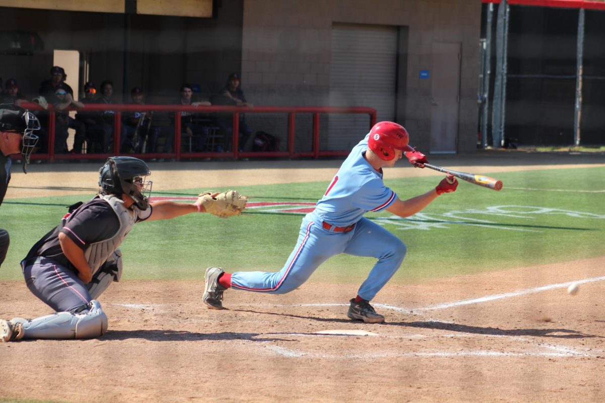 Palomar baseball player in a light blue uniform squares up with the bat and lays a bunt down the third-base side.